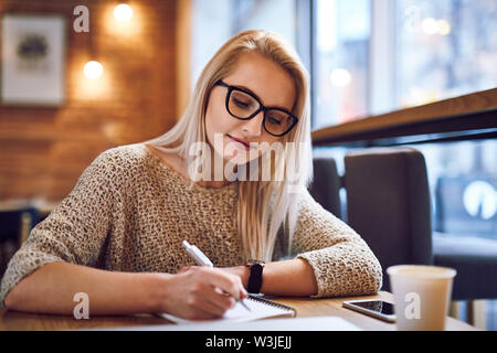 Junge Frau in einem Café zu studieren Stockfoto
