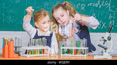 Die Chemie ist über Reaktion. Smart Schule Kinder Durchführung Chemie Test im Labor. Kleine Schülerinnen lernen Chemie während der Schulzeit. Wenig Schüler halten den Reagenzgläsern in Chemie Labor. Stockfoto