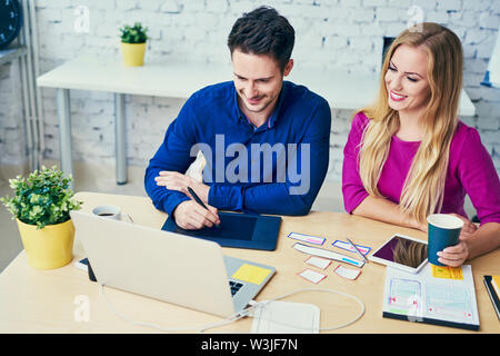 Zwei Web Designer duscussing neue Start-up-Arbeiten am Laptop Stockfoto