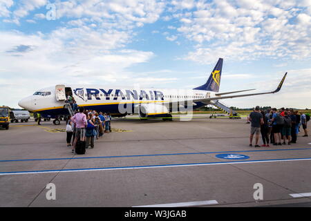 MEMMINGEN, Deutschland - 6. JULI 2019: Menschen boarding Ryanair der Irischen Low-Cost-Airline Flugzeug Boeing 737 mit bewölktem Himmel Hintergrund Am 6. Juli, 2019 in Memmin Stockfoto