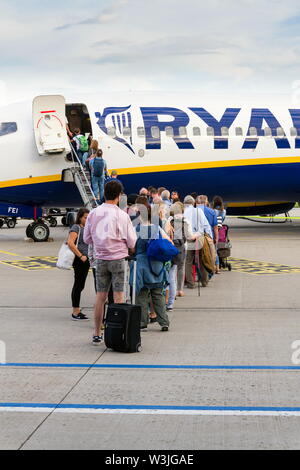 MEMMINGEN, Deutschland - 6. JULI 2019: Menschen boarding Ryanair der Irischen Low-Cost-Airline Flugzeug Boeing 737 mit bewölktem Himmel Hintergrund Am 6. Juli, 2019 in Memmin Stockfoto