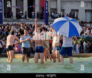 Cricket-Fans feiern den Sieg der englischen Weltmeisterschaft, indem sie in den Brunnen des Trafalgar Square eintauchen, wo das Finale live übertragen wurde. Stockfoto