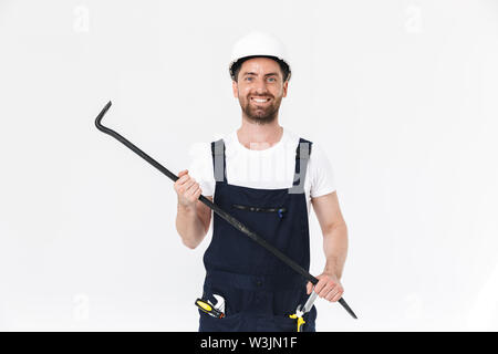 Porträt einer stattlichen Bärtigen builder Mann, Overalls, die auf weißem Hintergrund, holding Brecheisen Stockfoto