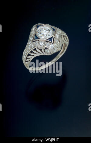 Einen filigranen Stil antike Diamond Engagement Ring mit einem Plus carat Zentrum Stein und die von Akzent Seite Diamanten und Saphiren in plati umgeben Stockfoto