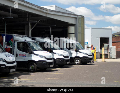 Eine Linie von stationären Tesco home Lieferwagen in schwindenden Perspektive in ihren Laden Buchten warten, bevor Sie sich auf ihren Routen geladen werden. Stockfoto