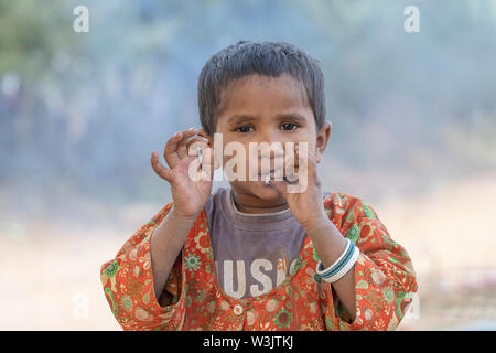 PUSHKAR, INDIEN - November 15, 2018: indische Mädchen rauchen Zigarette in der Nähe der Stadt Pushkar, Rajasthan, Indien. Von früher Kindheit an, indische Kinder ar Stockfoto