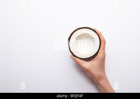 7/8-Ansicht von Frau mit Reife Kokosnuss halbe auf weißem Hintergrund mit Kopie Raum Stockfoto