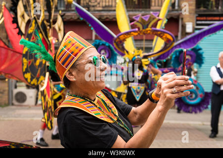 Ein Darsteller die Fotos vor dem Start der Acton Carnival Parade, 2019. Der Crown Street, Acton London UK Stockfoto