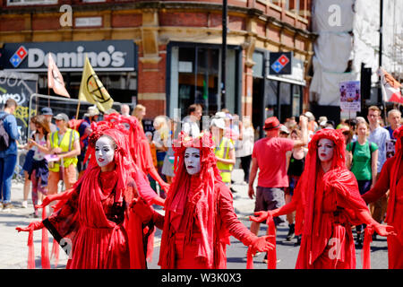 Bristol, UK, 16. Juli 2019. Rote Brigade an Tag 2 des Aussterbens Aufstandsbewegung Sommer Aufstand, die Besetzung von Bristol Bridge weiter. Der Protest ist es, das Bewusstsein für die Geschwindigkeit des Klimawandels und der Mangel an Maßnahmen, die Sie zu stoppen. Die Demonstranten haben mit lokalen Agenturen gearbeitet, um einen sicheren und friedlichen Protest, Polizei vorhanden sind und Umleitungen an Ort und Stelle zu gewährleisten. Weitere Berufe sind in der ganzen Stadt diese Woche geplant. Marschieren College Green. Credit: Herr Standfast/Alamy leben Nachrichten Stockfoto