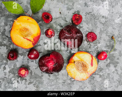 Frische reife Sommer Beeren und Früchte, Pfirsiche, Aprikosen, Kirschen und Pflaumen in einer runden Platte auf den Tisch. Stockfoto