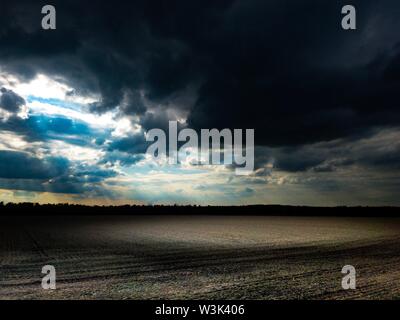 Dunkle bewölkten Himmel mit Sonne auf dem Feld in dunklen Atmosphäre Stockfoto