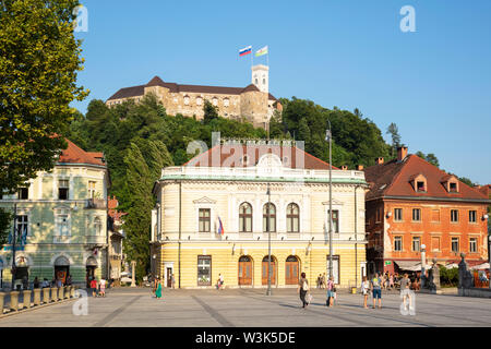 Die Burg von Ljubljana mit slowenischer Flagge hinter der Slovenska filharmonija Slowenische Philharmonie Gebäude Congress square Ljubljana Slowenien EU fliegen Stockfoto