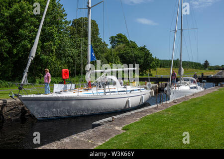 Zwei Yachten Manöver in Stellung LOCK 10 vor der Wasserstand abgesenkt wird - Dunardry auf Crinan Canal, Argyll und Bute, Schottland, Großbritannien Stockfoto