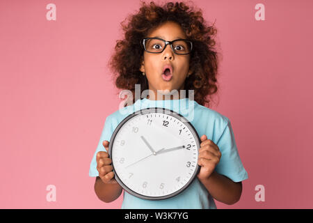 Schockiert Schulmädchen, die große Uhr im Studio Stockfoto