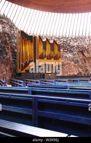 Innenraum der Temppeliaukio Kirche (Helsinki, Finnland). Blau Holz- Sitze mit Orgel im Hintergrund. Stockfoto