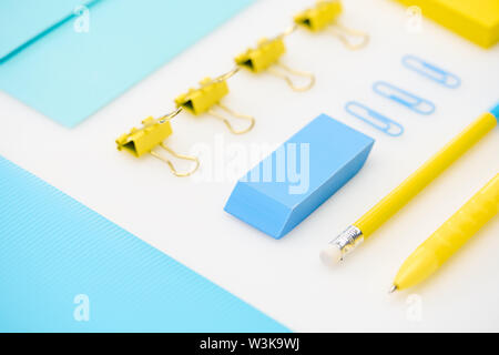 Flach blau Radiergummi, Büroklammern, Ordner, Umschlag, den gelben Stift, Bleistift, Aufkleber in den weißen Hintergrund Stockfoto