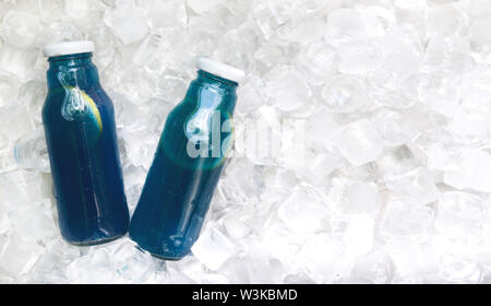 Blaues Wasser mit frischer Zitrone in Glas Flasche auf Eis Stockfoto