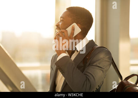 Afro Finanzier am Telefon sprechen im Flughafen Terminal Stockfoto