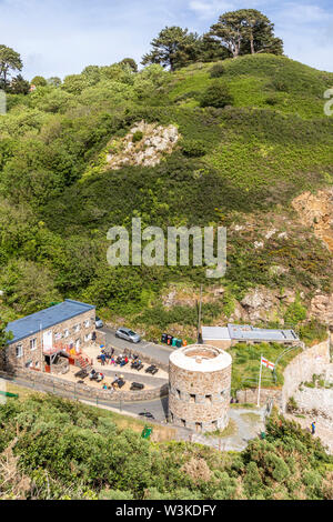 Auf der Suche nach unten von der Küste weg auf den Napoleonischen Schlupfloch Turm mit Blick auf Petit Bot Bay auf der schönen robusten Südküste von Guernsey UK Stockfoto