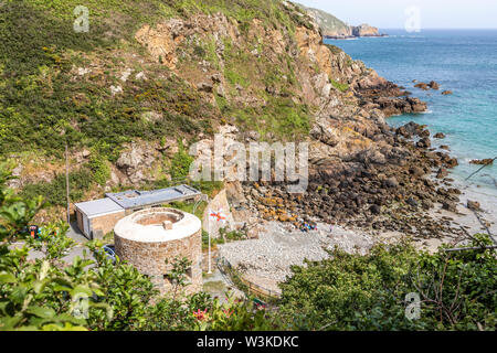 Auf der Suche nach unten von der Küste weg auf den Napoleonischen Schlupfloch Turm mit Blick auf Petit Bot Bay auf der schönen robusten Südküste von Guernsey UK Stockfoto