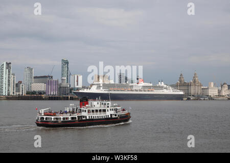 Liverpool, Großbritannien. 16. Juli 2019. Die mersey Fähre Royal Iris verläuft vor der Queen Mary 2 angedockt in Liverpool. Die 149.000-Tonnen Schiff das größte Passagierschiff, das jemals gebaut wurde ist auf volle Ansicht heute bei Cruise Liner Terminal der Stadt festgemacht. 300 Passagiere wird Ihr im Rahmen einer transatlantischen Reise nach New York über Reykjavik und Halifax, Nova Scotia. Credit: Ken Biggs/Alamy leben Nachrichten Stockfoto