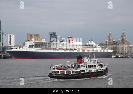 Liverpool, Großbritannien. 16. Juli 2019. Die mersey Fähre Royal Iris verläuft vor der Queen Mary 2 angedockt in Liverpool. Die 149.000-Tonnen Schiff das größte Passagierschiff, das jemals gebaut wurde ist auf volle Ansicht heute bei Cruise Liner Terminal der Stadt festgemacht. 300 Passagiere wird Ihr im Rahmen einer transatlantischen Reise nach New York über Reykjavik und Halifax, Nova Scotia. Credit: Ken Biggs/Alamy leben Nachrichten Stockfoto