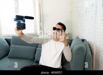 Jungen netten Mann in legere Kleidung Stil holding Kamera schießen self portrait Foto oder Video Streaming zu Hause. In den Sozialen Medien Einflussnehmer Stockfoto