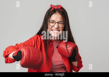 Aggressive Jugendmädchen Legere Outfit stehen über grauer Hintergrund isoliert, Boxhandschuh, Boxen Stockfoto