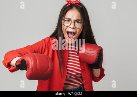 Aggressive Jugendmädchen Legere Outfit stehen über grauer Hintergrund isoliert, Boxhandschuh, Boxen Stockfoto