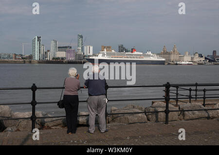 Liverpool, Großbritannien. 16. Juli 2019. 2 Rentner den Blick über den Fluss Mersey auf die Queen Mary 2 in Liverpool angedockt. Die 149.000-Tonnen Schiff das größte Passagierschiff, das jemals gebaut wurde ist auf volle Ansicht heute bei Cruise Liner Terminal der Stadt festgemacht. 300 Passagiere wird Ihr im Rahmen einer transatlantischen Reise nach New York über Reykjavik und Halifax, Nova Scotia. Credit: Ken Biggs/Alamy leben Nachrichten Stockfoto