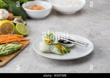 Lecker und serviert Frühlingsrollen mit Sojasauce auf weiße Platte mit Metall-Sticks Stockfoto