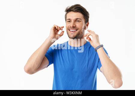 Foto Nahaufnahme Der unrasierte Mann in casual t-shirt und lächelnd zur Seite schauen beim Tragen der drahtlose Kopfhörer auf weißem Hintergrund Stockfoto