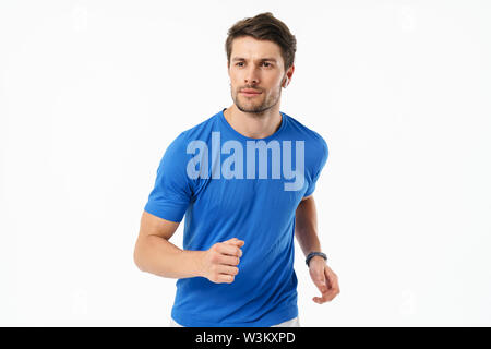 Foto Nahaufnahme von gutaussehenden Mann im casual t-shirt lächelnd und läuft beim Tragen der drahtlose Kopfhörer auf weißem Hintergrund Stockfoto