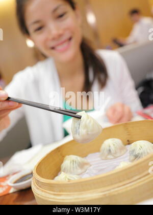 Xiao Long bao/xiaolongbao Suppe Knödel. Frau essen Chinesisch Shanghai gedämpft Knödel Brötchen mit Stäbchen im Restaurant in China. Stockfoto