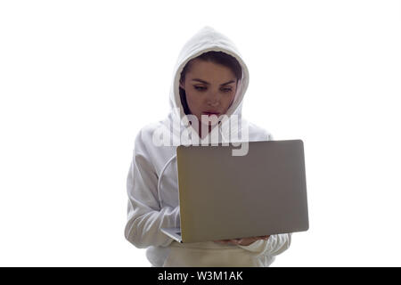 Eine Frau in einer Haube ist mit einem Laptop. Hacker ist mit einem Laptop. Stockfoto