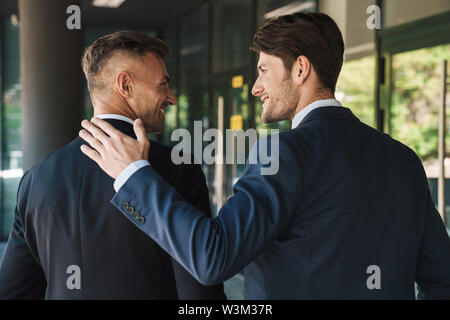 Portrait Nahaufnahme von der Rückseite der zwei zuversichtlich Unternehmer Partner in Anzug außerhalb Job Center während der Sitzung gekleidet Stockfoto