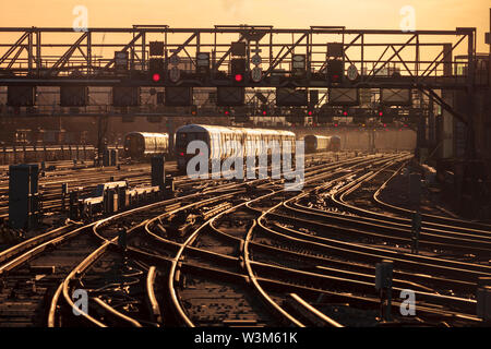 Züge, die während der morgendlichen Londoner Pendlerzeit von der Londoner Brücke bei Sonnenaufgang an- und abfahren Stockfoto