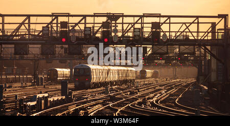 Süd- (GTR) und südöstliche Züge, die bei Sonnenaufgang von der Londoner Brücke kommend und abfahren, während der morgendlichen Londoner Pendlerzeit Stockfoto