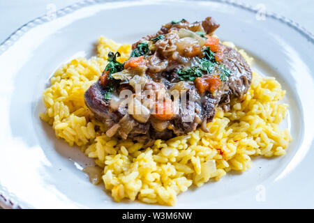 Osso Buco, Kalbfleisch Schäfte, die in Wein mit Mailänder Safranrisotto geschmort werden. Traditionelle Speisen. Stockfoto