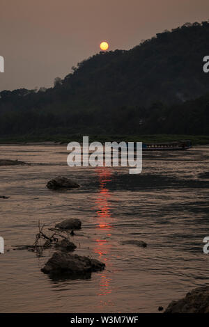 Blick auf den Fluss Kreuzfahrt Schiff auf dem Mekong und Chomphet Bezirk über den Fluss in Luang Prabang, Laos, bei Sonnenuntergang. Stockfoto