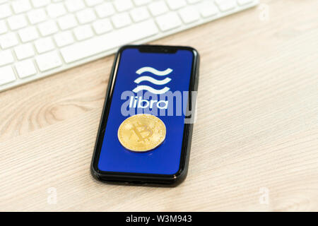 12 Juli 2019, Ljubljana Slowenien - Smartphone mit Waage Logo neben Bitcoin Münze. Facebook Neue globale cryptocurrency für Transaktionen Stockfoto