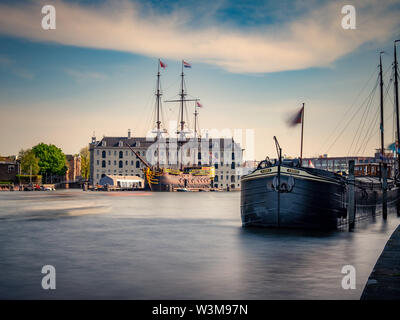 Die scheepvaart Naval Museum mit Vintage Lastkähne im Vordergrund, im historischen Hafen, Amsterdam, Niederlande Stockfoto