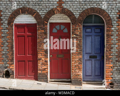 Drei hübsche Reihenhaus aus Holz Haustüren in gewölbten Backstein Türen, Lewes, England, Grossbritannien Stockfoto