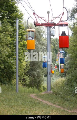 Charkow, Ukraine - Juni 30, 2019: Seilbahn von bunten Ständen im Hintergrund einer dichten, grünen Park Stockfoto