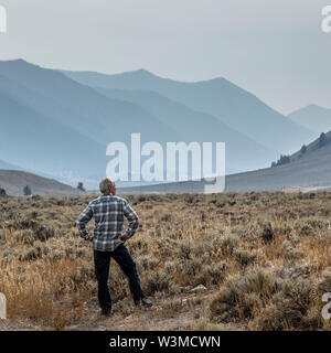 Älterer Mann in Feld von Bergen in Sun Valley, Idaho, USA