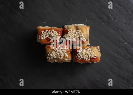 Sushi mit Sesam auf schwarze Oberfläche Stockfoto