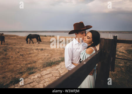 Junges Paar die in Feld von Pferden Stockfoto