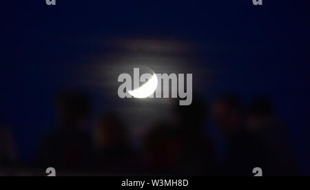 Brighton, UK, 16. Juli 2019 - Dienstag Nacht Tänzer auf Brighton Musikpavillon mit der teilweisen Mondfinsternis der Mond hinter Juli Buck auf den 50. Jahrestag der Apollo 11 Start auf seine Mission zum Mond 1969: Simon Dack/Alamy leben Nachrichten Stockfoto