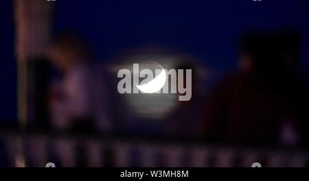 Brighton, UK, 16. Juli 2019 - Dienstag Nacht Tänzer auf Brighton Musikpavillon mit der teilweisen Mondfinsternis der Mond hinter Juli Buck auf den 50. Jahrestag der Apollo 11 Start auf seine Mission zum Mond 1969: Simon Dack/Alamy leben Nachrichten Stockfoto