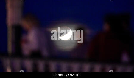 Brighton, UK, 16. Juli 2019 - Dienstag Nacht Tänzer auf Brighton Musikpavillon mit der teilweisen Mondfinsternis der Mond hinter Juli Buck auf den 50. Jahrestag der Apollo 11 Start auf seine Mission zum Mond 1969: Simon Dack/Alamy leben Nachrichten Stockfoto